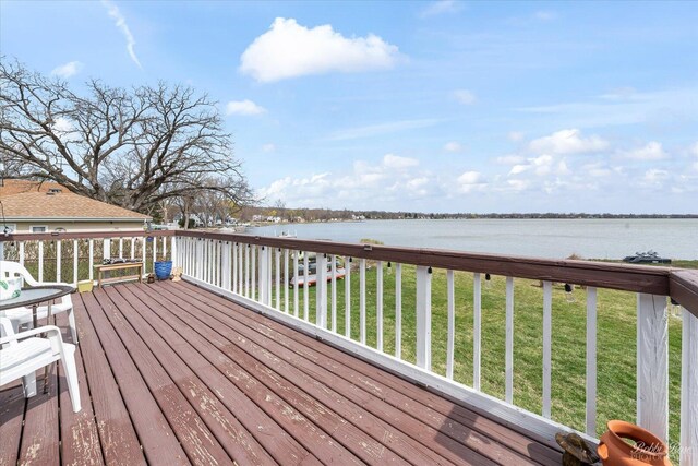 deck with a lawn and a water view