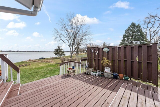 wooden deck with a lawn and a water view