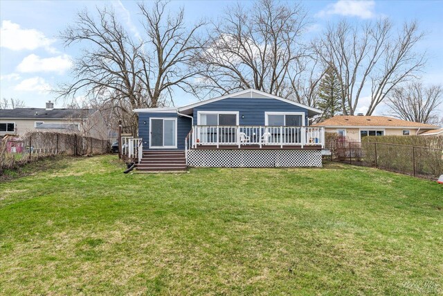back of property featuring a lawn, a deck, and a fenced backyard