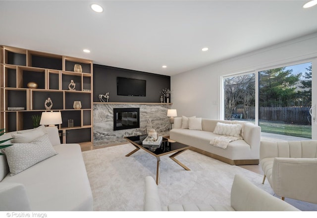 living area featuring wood finished floors, a high end fireplace, and recessed lighting