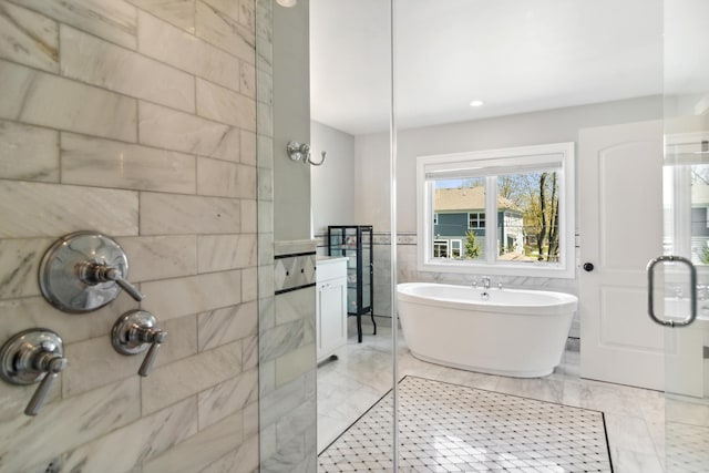 bathroom with a shower stall, a freestanding tub, and tile walls