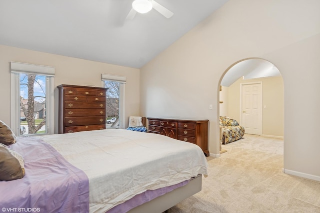 carpeted bedroom featuring arched walkways, baseboards, a ceiling fan, and lofted ceiling