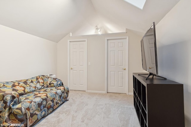 living area with baseboards, vaulted ceiling, and light carpet