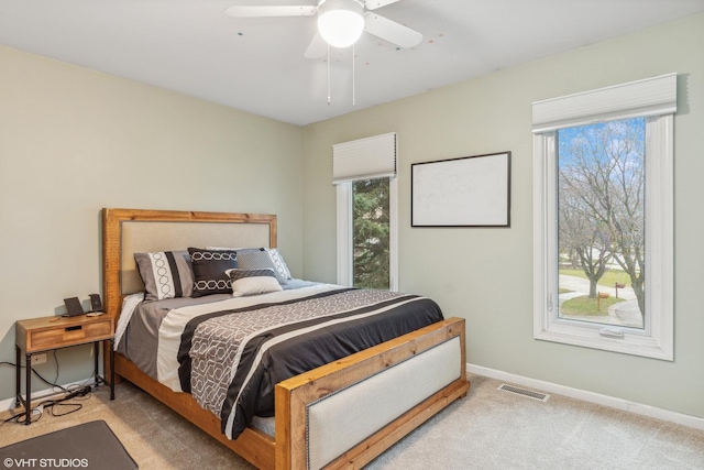 bedroom with baseboards, ceiling fan, carpet flooring, and visible vents