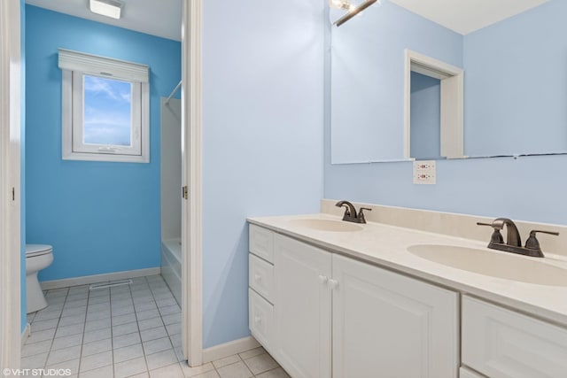 bathroom with double vanity, toilet, a sink, and tile patterned flooring