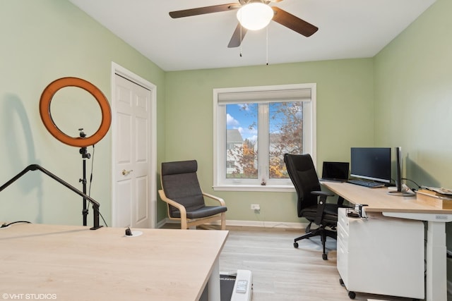 office area with baseboards, ceiling fan, and light wood finished floors