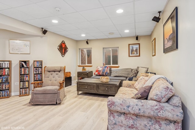 living room with baseboards, recessed lighting, a paneled ceiling, and wood finished floors