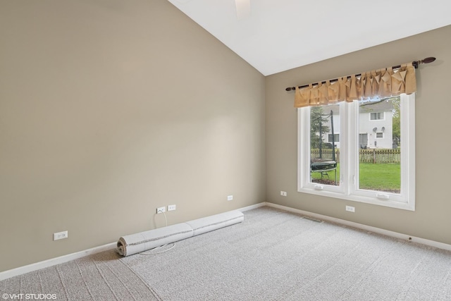 carpeted empty room with visible vents, baseboards, and vaulted ceiling