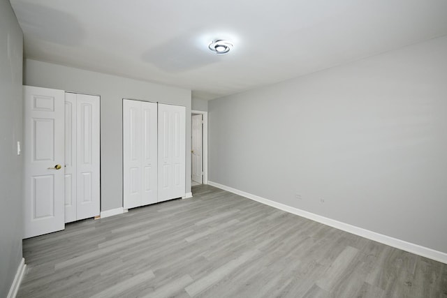 212A Collen Dr Unit 104, Lombard, IL 60148 - unfurnished bedroom with baseboards, light wood-type flooring, and two closets
