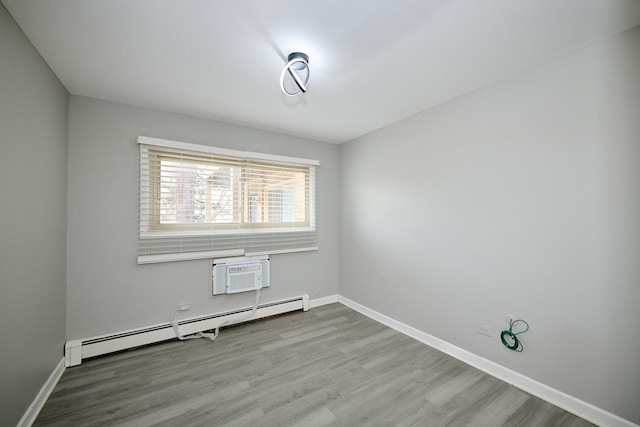 212A Collen Dr Unit 104, Lombard, IL 60148 - unfurnished room featuring a wall mounted air conditioner, a baseboard radiator, baseboards, and wood finished floors
