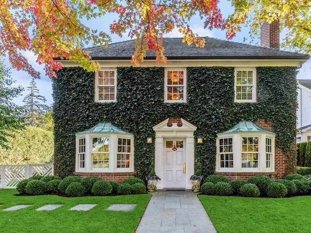85 Sunset Pl, Lake Forest, IL 60045 - colonial-style house with a chimney, a front yard, fence, and brick siding