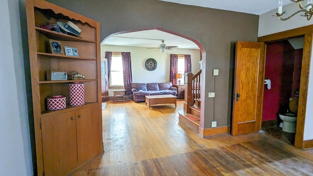 245 N Main St, Cisco, IL 61830 - living room featuring arched walkways, wood-type flooring, stairs, and ceiling fan