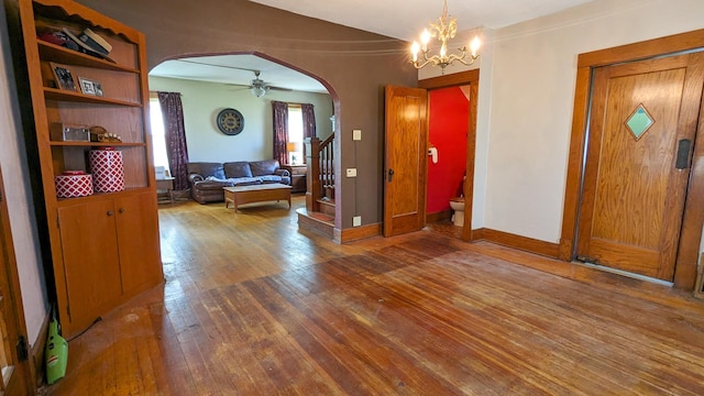 245 N Main St, Cisco, IL 61830 - interior space featuring baseboards, arched walkways, hardwood / wood-style flooring, stairway, and ceiling fan with notable chandelier