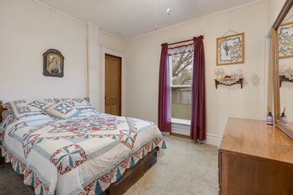 bedroom with light carpet and ornamental molding