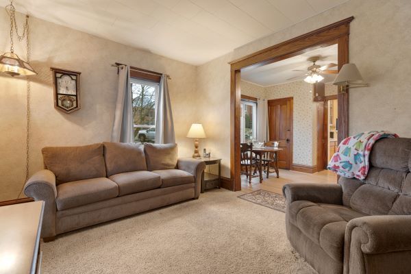living area with carpet floors, a ceiling fan, and wallpapered walls