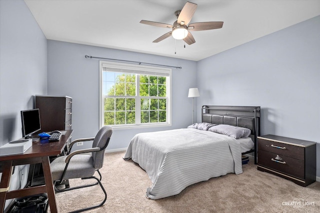 carpeted bedroom featuring an office area, ceiling fan, and baseboards