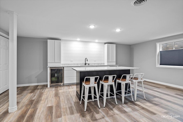 16432 S Harmon Ln, Plainfield, IL 60586 - kitchen with wine cooler, a kitchen island, a kitchen breakfast bar, white cabinets, and recessed lighting