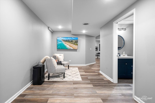 living area with wood finished floors, baseboards, and recessed lighting