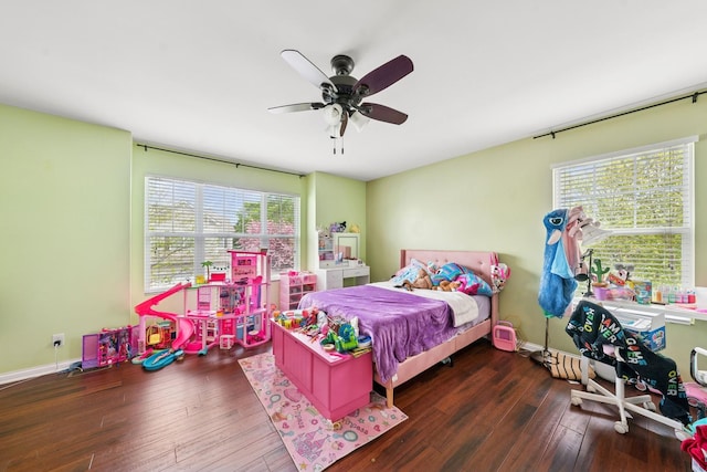 bedroom featuring baseboards, multiple windows, hardwood / wood-style floors, and ceiling fan