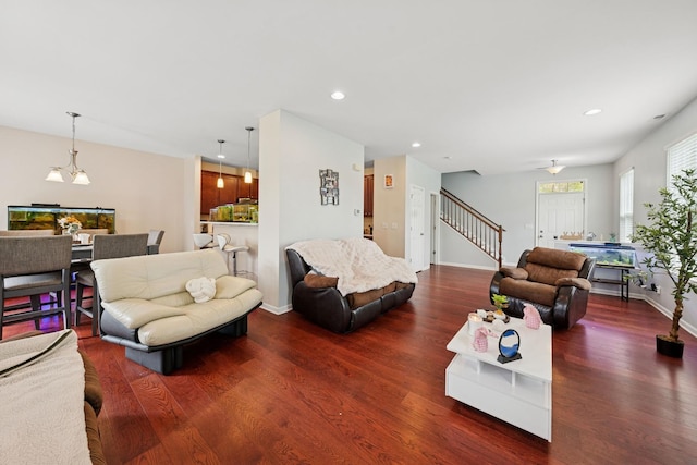 living room featuring stairs, baseboards, recessed lighting, and wood finished floors