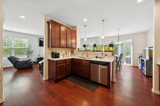 kitchen featuring stainless steel dishwasher, a sink, a peninsula, light countertops, and dark wood-style floors