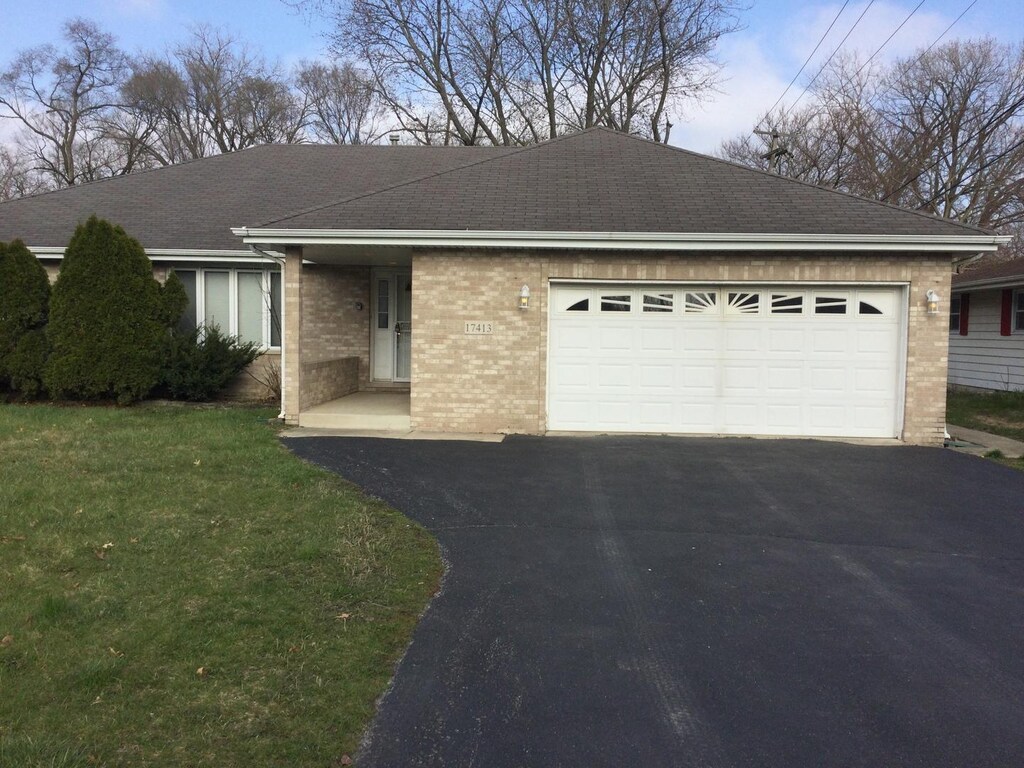 17413 Center Ave, East Hazel Crest, IL 60429 - view of front of home with roof with shingles, a front lawn, aphalt driveway, brick siding, and a garage