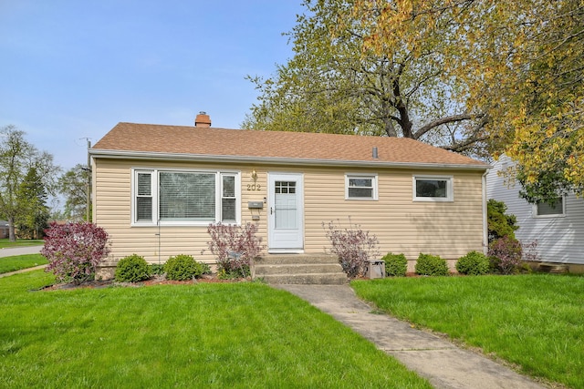 view of front facade with a chimney and a front yard