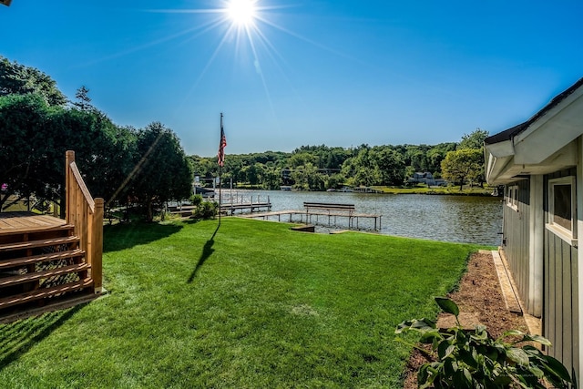 view of yard with a water view and a boat dock