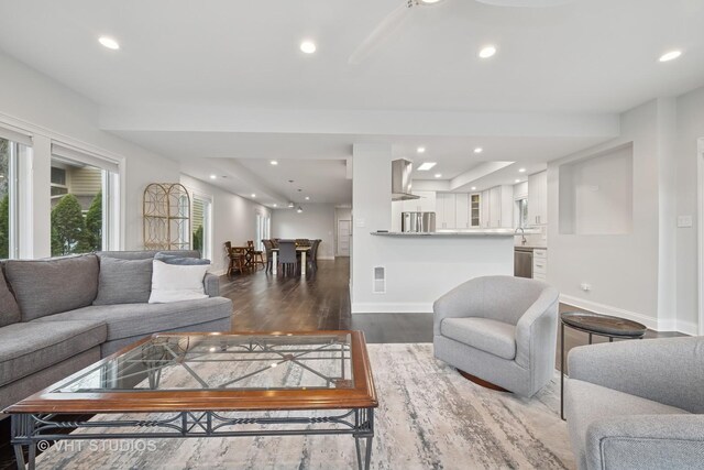 living room with recessed lighting, baseboards, visible vents, and wood finished floors
