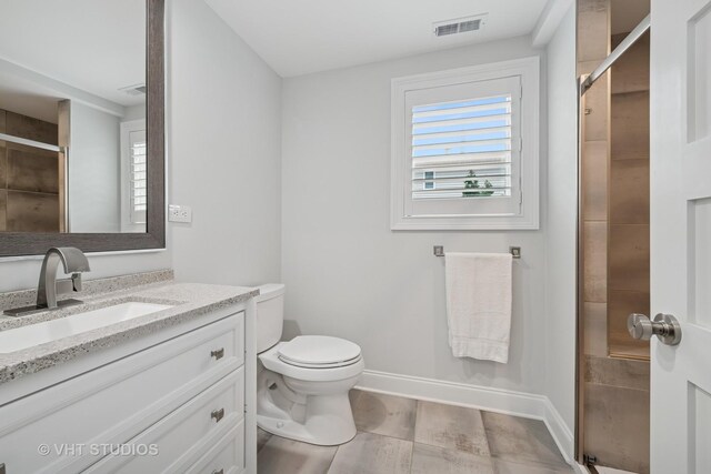 full bathroom featuring visible vents, vanity, toilet, baseboards, and a shower stall
