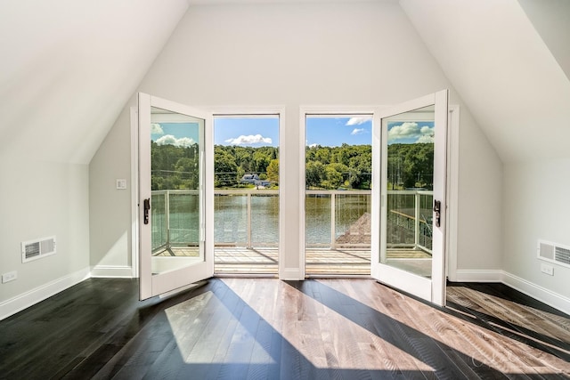 additional living space with dark wood-style flooring, visible vents, a healthy amount of sunlight, and lofted ceiling
