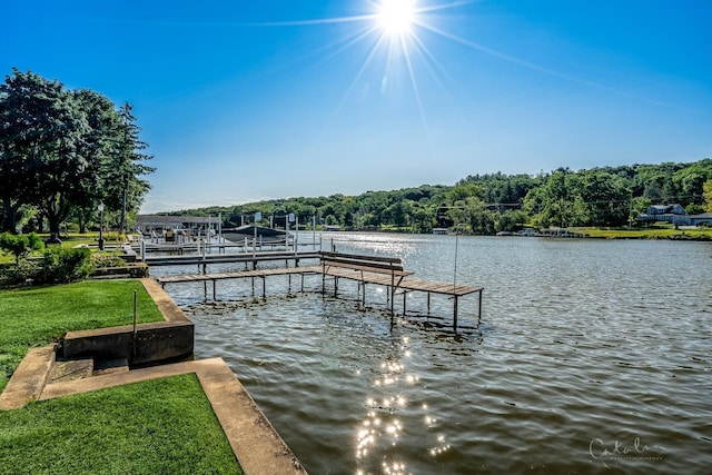view of dock with a lawn, a water view, and boat lift