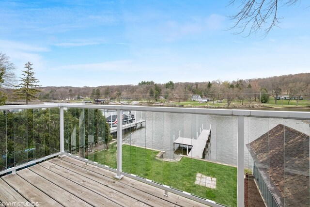view of dock featuring a lawn and a water view