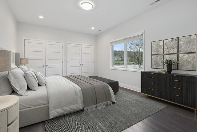 bedroom featuring recessed lighting, baseboards, multiple closets, and dark wood finished floors