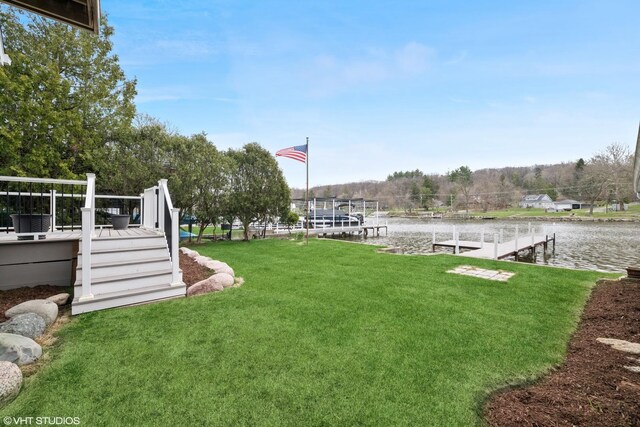 view of yard featuring a deck with water view and a dock