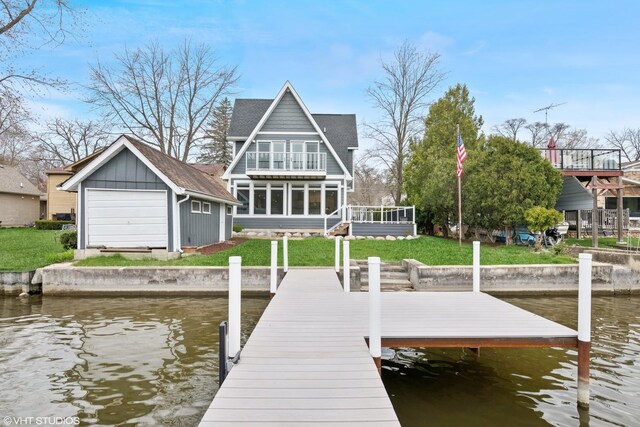 dock area with a lawn, a water view, and a balcony