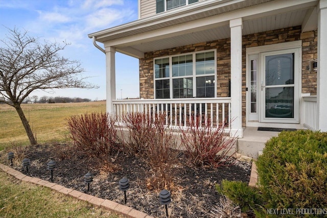 entrance to property with stone siding and covered porch