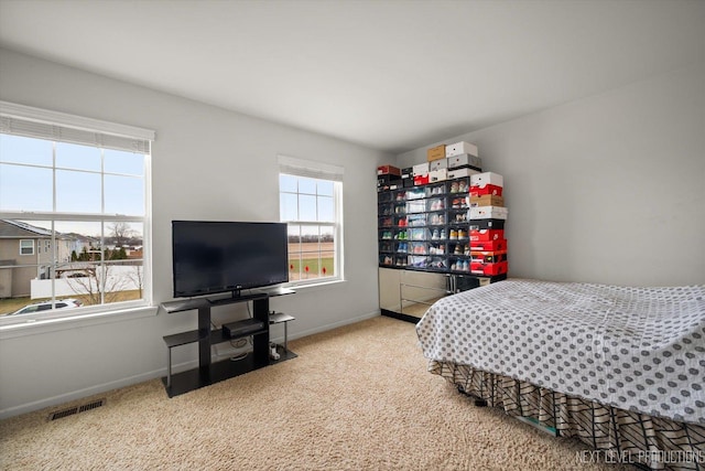 carpeted bedroom with visible vents and baseboards