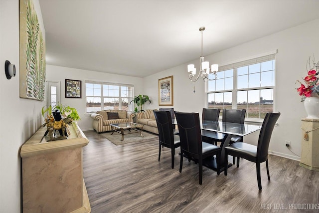 dining area featuring baseboards, an inviting chandelier, and wood finished floors