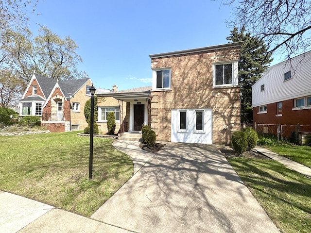 view of front of house featuring fence, brick siding, and a front yard