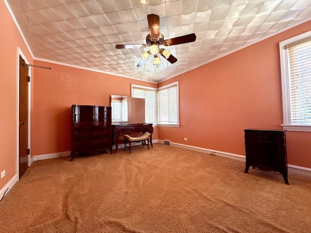 sitting room with baseboards, carpet flooring, ceiling fan, and crown molding