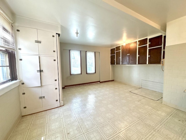 unfurnished room featuring a wealth of natural light, baseboards, and light floors