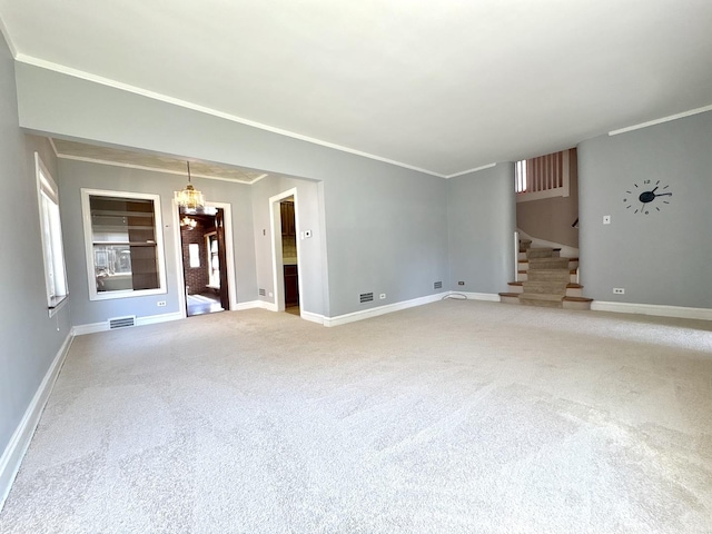 unfurnished living room with visible vents, baseboards, ornamental molding, and stairway