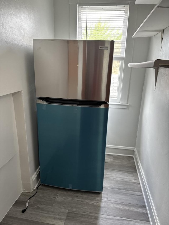 room details featuring baseboards, freestanding refrigerator, and wood finished floors