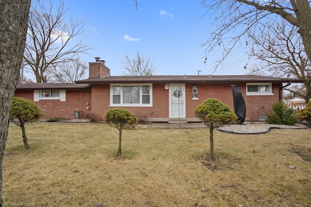 ranch-style house with brick siding, a chimney, and a front lawn
