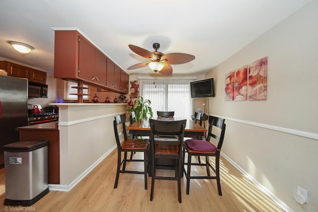 dining space featuring light wood-style floors, ceiling fan, and baseboards