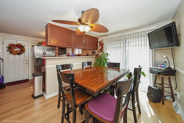 dining room featuring light wood-type flooring and a ceiling fan