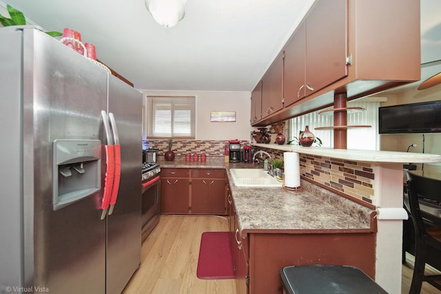 kitchen with light wood-type flooring, light countertops, a sink, stainless steel appliances, and backsplash