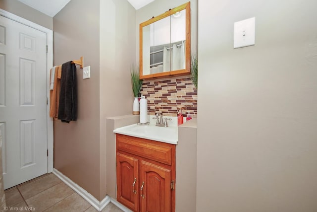 bathroom with tile patterned floors, decorative backsplash, baseboards, and vanity