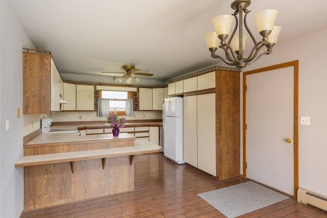 3449 E Cleveland St, Ladd, IL 61329 - kitchen with a peninsula, ceiling fan with notable chandelier, freestanding refrigerator, baseboard heating, and range